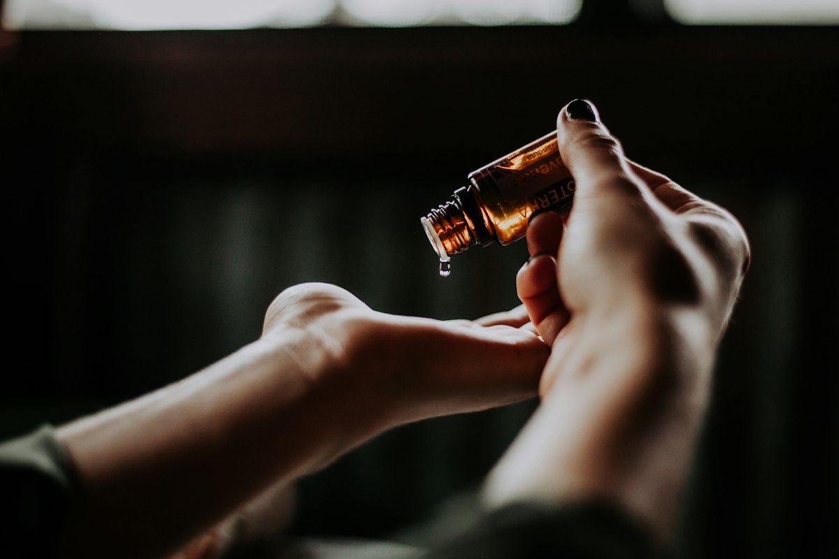 Flacon de produit cosmétique versé dans la main, photo d’illustration